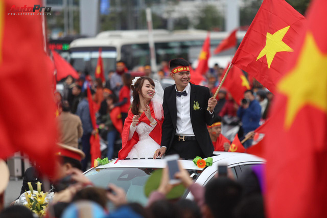 Mắc kẹt trên đường, cô dâu và chủ rể mở cửa sổ trời ô tô hoà cùng dòng người mừng U23 Việt Nam về nước - Ảnh 1.