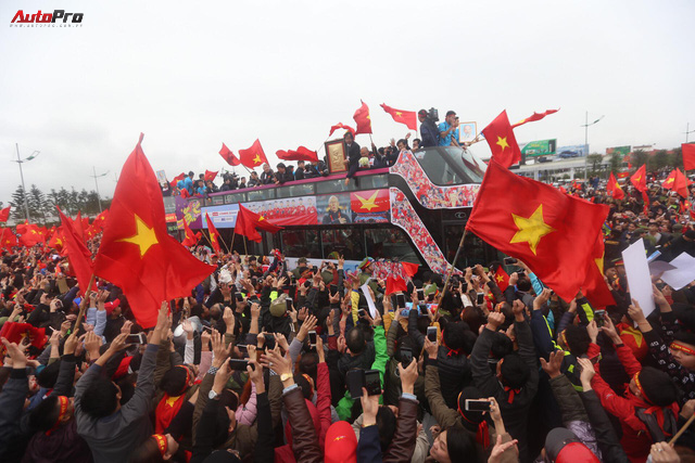 Chùm ảnh: Xe buýt hai tầng chở U23 Việt Nam chìm trong biển người với sắc cờ đỏ rực - Ảnh 1.