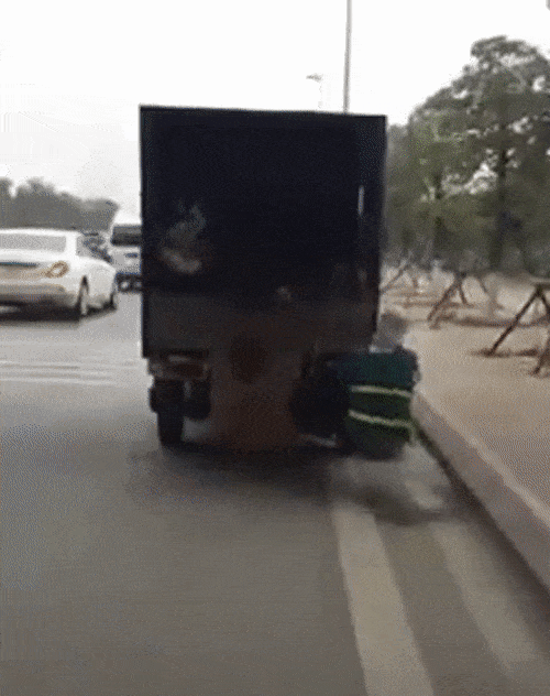 Clip: Người phụ nữ mặc áo công nhân vệ sinh môi trường bám đuôi ô tô, vừa đi vừa nhặt rác bên đường nhanh thoăn thoắt - Ảnh 2. Clip: Người phụ nữ mặc áo công nhân vệ sinh môi trường bám đuôi ô tô, vừa đi vừa nhặt rác bên đường nhanh thoăn thoắt - Ảnh 2.