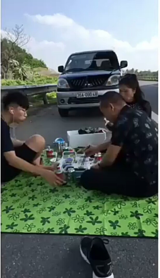 Hãy cùng theo dõi bức ảnh Livestream cảnh gia đình hoan hỉ ăn nhậu trên cao tốc, tạo nên cảnh tượng đầy vui nhộn và ấm áp đầy tình thân. Chắc chắn bạn sẽ thấy sự đoàn kết và hạnh phúc của một gia đình Việt Nam trên con đường giao thông sầm uất.