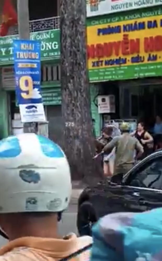 Dùng gậy sắt đập xe BMW, nam thanh niên bị nữ tài xế cầm ô rượt đuổi trên đường phố Sài Gòn - Ảnh 1.
