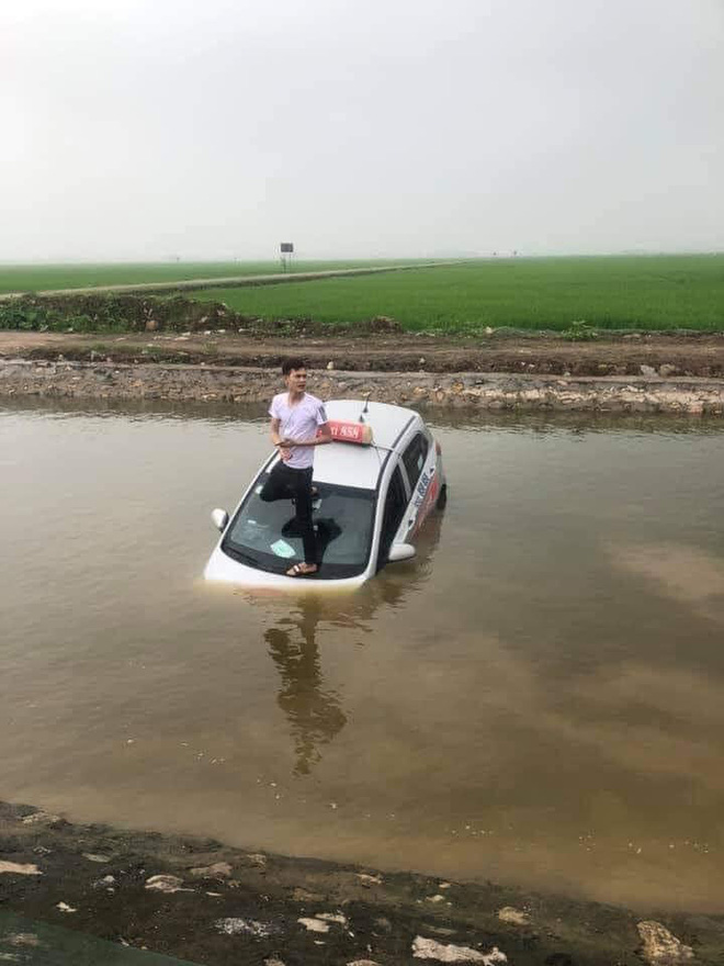 Taxi không rõ nguyên nhân nằm chìm dưới mương nước, tài xế loay hoay đạp cửa thoát ra ngoài - Ảnh 3.