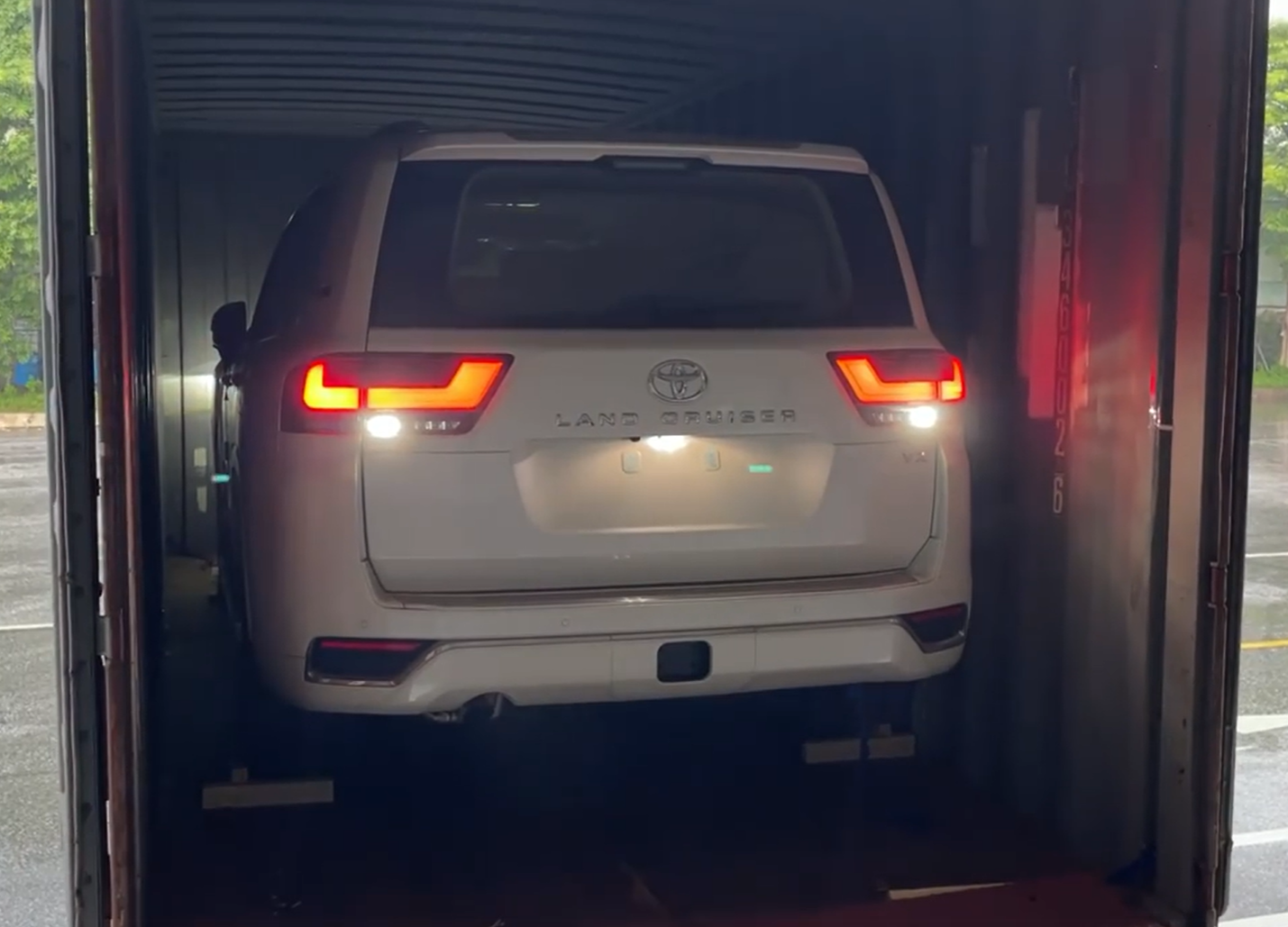 Chật vật lùi Toyota Land Cruiser ra khỏi container, tài xế vào xe bằng cách nào khi không mở được cửa? - Ảnh 1.