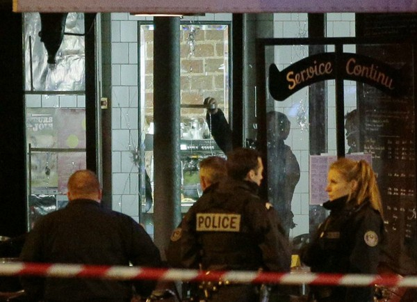 Cảnh sát Paris khám xét và tìm bằng chứng còn xót lại tại quán cà phê La Belle Equipe trên phố Rue de Charonne, một trong những nơi xảy ra vụ khủng bố. Ảnh: New York Times 