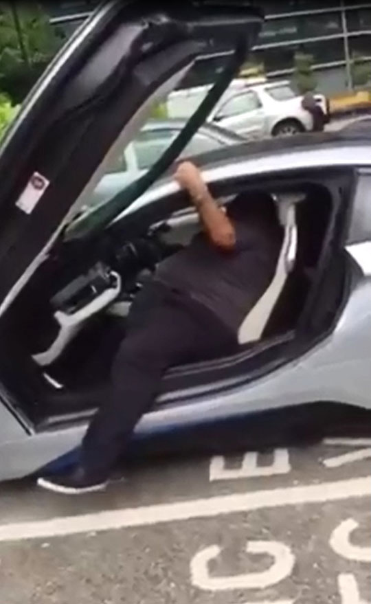
Người đàn ông to béo bước một chân ra khỏi xe.
