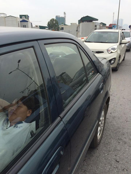 
Một tài xế tranh thủ ngủ một giấc vì tắc đường quá lâu.
