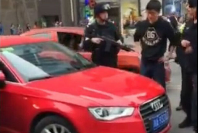
Lực lượng đặc nhiệm cầm súng đứng quanh người lái chiếc Audi.
