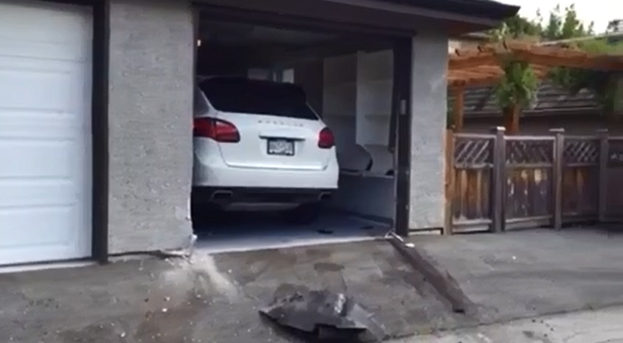 Chiếc Porsche Cayenne đã khiến tường của gara bị vỡ. Ảnh cắt từ video