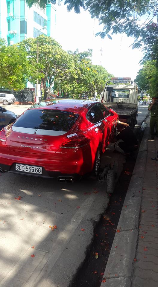 Chiếc Porsche Panamera màu đỏ bị niêm phong ở cốp và cửa xe trước khi bị kéo đi.