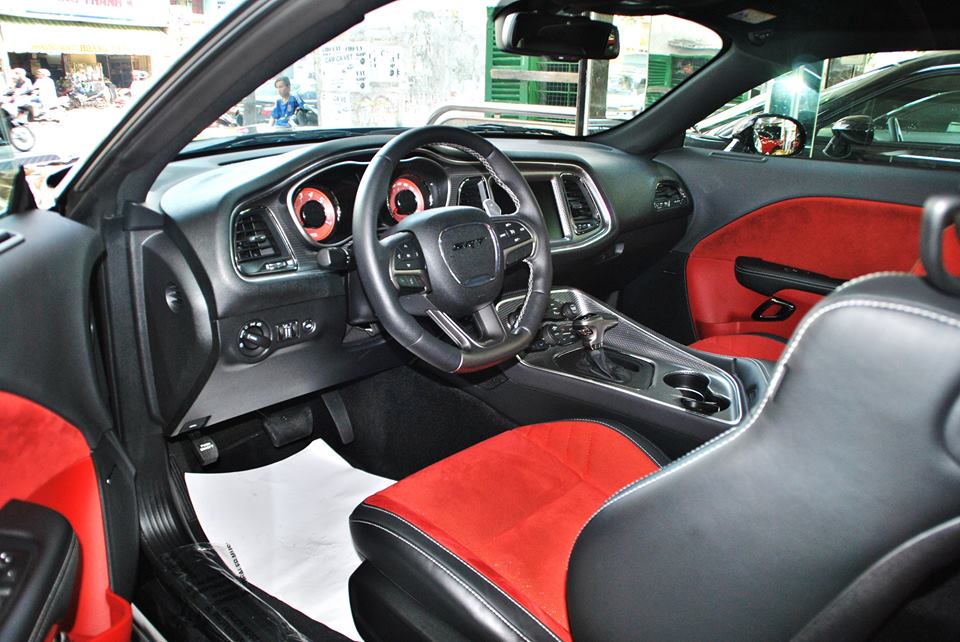 
Trái ngược với tông màu đen ở ngoại thất, bên trong khoang lái của chiếc Challenger SRT Hellcat 2015 đầu tiên tại Việt Nam được trang bị tông màu đen-đỏ khá nổi bật.
