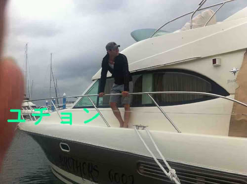 Yoochun đứng trên chiếc du thuyền của mình.