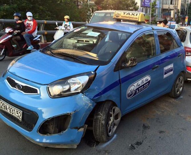 Chiếc taxi màu xanh bị hư hỏng khá nặng trong vụ tai nạn.