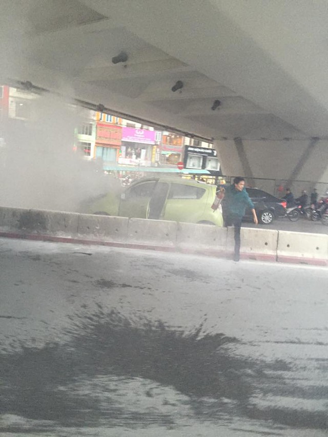 
Một người đàn ông cầm bình cứu hỏa để dập lửa cho chiếc xe. Ảnh: Thai Minh Quan/Otofun
