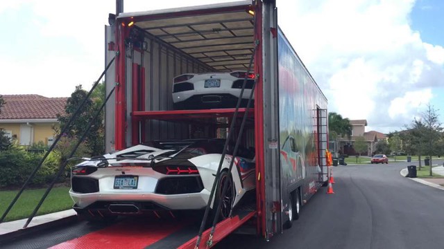 
Hai chiếc Lamborghini Aventador màu trắng nằm trong thùng xe container.
