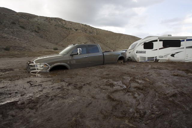 
Trong ảnh là một chiếc xe bán tải và toa moóc bị kẹt trong bùn sâu tại California.
