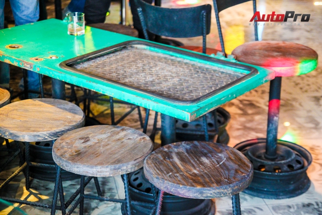 Mặt bàn làm bằng cánh cửa xe ô tô. Chân ghế là từ những chiếc vành cũ.