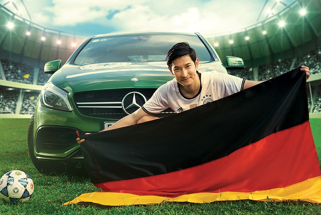 
Huy Khánh căng quốc kỳ Đức bên cạnh chiếc xe thể thao của Mercedes-Benz.
