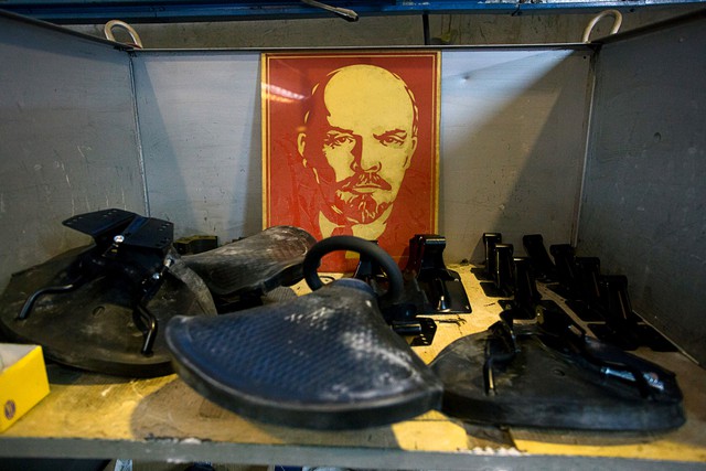 
Một bức ảnh của nhà lãnh đạo đảng cộng sản Vladimir Lenin quá cố nằm trên giá, cạnh những chi tiết cũ của xe Ural trong nhà máy.

