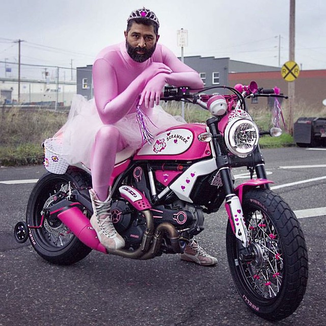 
Không dừng ở đó, chiếc Ducati Scrambler theo phong cách Hello Kitty còn có những phụ kiện như tua rua ở đầu tay lái, còi màu hồng trên đầu xe và giỏ bằng nhựa màu trắng ở hai bên hông xe. Bên cạnh đó là hình ảnh chú mèo Hello Kitty và trái tim màu hồng xuất hiện khắp nơi.
