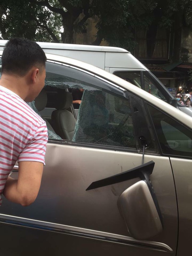 Cửa kính bên ghế phụ lái của chiếc Toyota Innova bị ném đá nên vỡ mảng lớn. Gương chiếu hậu bị gãy gập. Ảnh: Otofun
