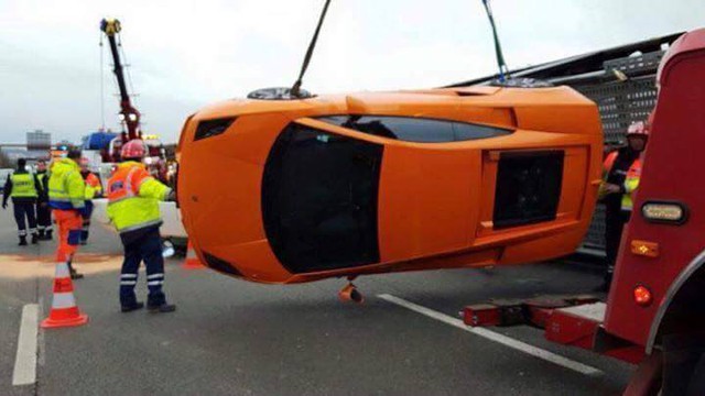 
Chiếc siêu xe Lamborghini Gallardo màu cam được xe cẩu đưa ra khỏi hiện trường vụ tai nạn.

