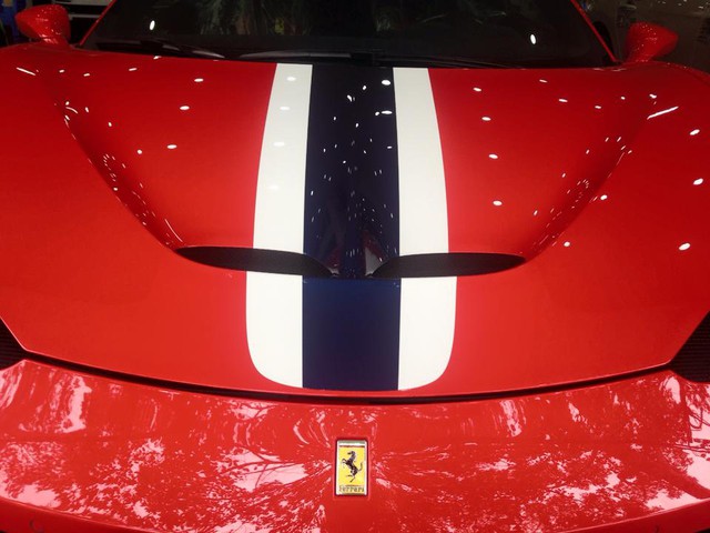 
Nổi bật trên nền đỏ rực đậm chất ngựa nòi nhà Ferrari là sọc lớn với màu xanh nằm giữa, hai bên là sọc trắng kéo dài từ khoang hành lý phía trước, lên trần và kết thúc phía đuôi xe tạo nên điểm nhấn quen thuộc cho 458 Speciale. Ảnh: Ken Tong

