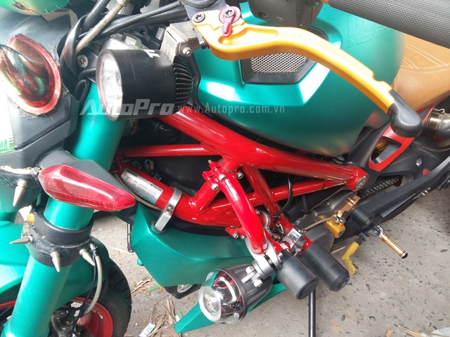Đối lập với màu xanh ngọc là bộ khung sườn và cặp mâm màu đỏ. Thêm vào đó là nhiều đồ chơi như tay thắng, gác chân và ghi đông màu đồng.