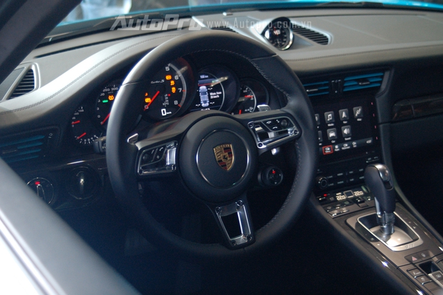 
Vô lăng 3 chấu thể thao của Porsche 911 Turbo S 2016 theo phong cách GT của 918 Spyder. Ngoài ra, vô lăng còn tích hợp thêm núm chuyển đổi các chế độ lái như Normal (thông thường), Sport (thể thao), Sport Plus (thể thao hơn nữa) và Individual (cá nhân). Nếu so với nút gạt trên những siêu xe Ferrari hay thao tác bấm nút dưới đáy vô lăng của Lamborghini Huracan để chọn chế độ lái, thiết kế của Porsche 911 Turbo S 2016 khá đơn điệu.
