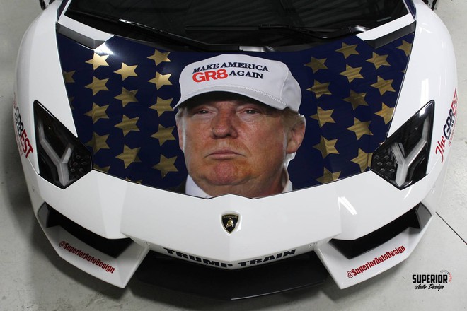 
Trên nền lá cờ của nước Mỹ là hình ảnh Donald Trump đội chiếc mũ trắng với dòng chữ Make America Great Again xuất hiện trang trọng ở phần nắp capô phía trước, ngoài ra, thông điệp bầu cử của vị tỷ phú còn xuất hiện ở bộ cửa cắt kéo trên siêu xe Lamborghini Aventador.
