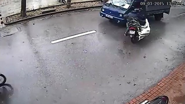 Vướng áo mưa, xe máy lao vào ôtô tải