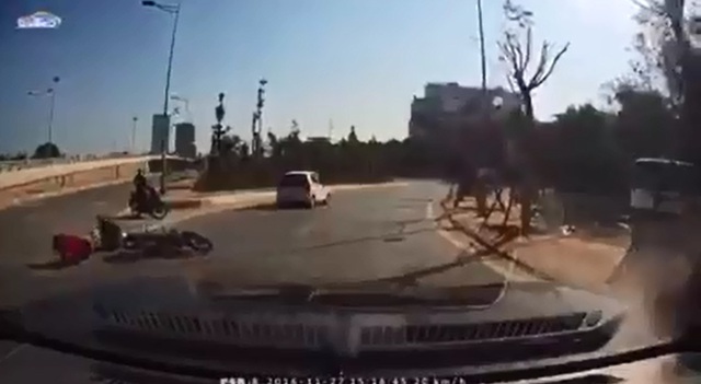 
Hai người ngồi trên chiếc xe máy ngã ra đường. Ảnh cắt từ video
