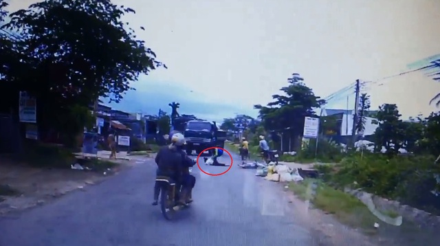 
Người điều khiển xe máy nằm sấp mặt trên đường. Ảnh cắt từ video
