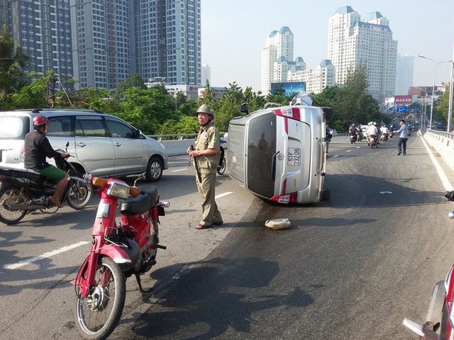 Xe 7 chỗ lộn nhiều vòng trên cầu Nguyễn Hữu Cảnh - Ảnh 1.