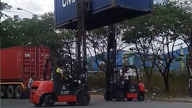 Clip: 2 tài xế xe nâng phối hợp như diễn xiếc để chuyển chiếc thùng container từ xe này sang xe khác