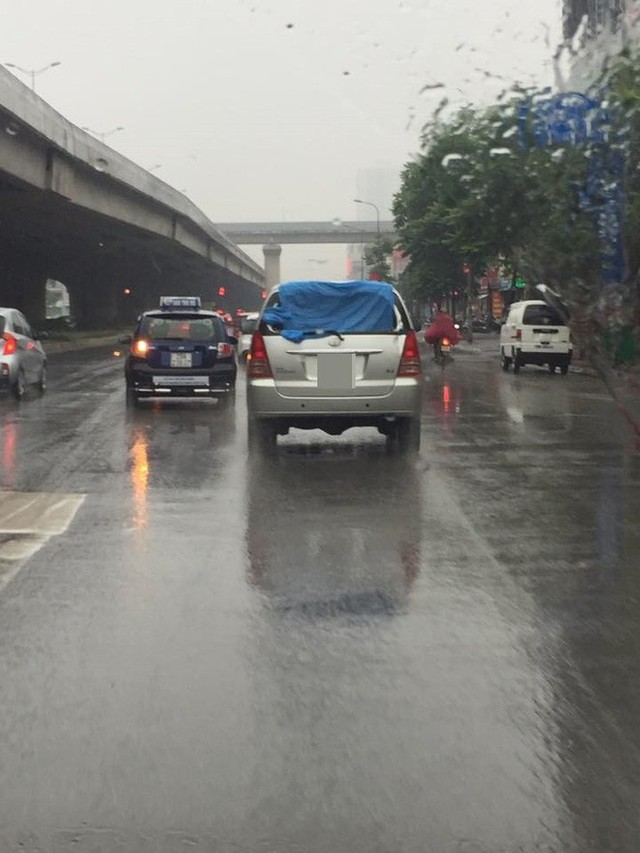 Đi ô tô mà vẫn phải mặc áo mưa: Hình ảnh trên phố Hà Nội khiến bao người bật cười - Ảnh 1.