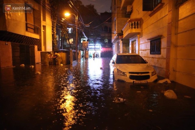 Mưa lớn kéo dài khiến đường phố Hà Nội hóa thành sông, nhiều người khốn đốn vì xe chết máy - Ảnh 19.