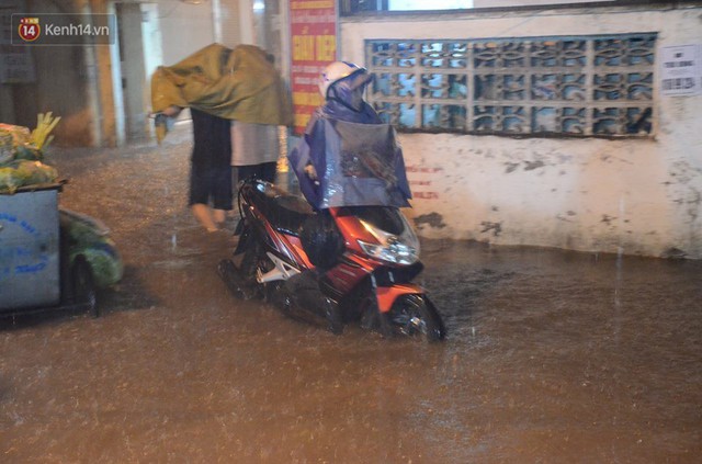 Mưa lớn kéo dài khiến đường phố Hà Nội hóa thành sông, nhiều người khốn đốn vì xe chết máy - Ảnh 9.