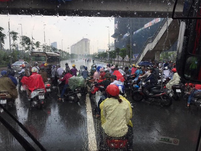 Hà Nội mưa dông lớn, hình ảnh trú mưa của người đi đường lại thành chủ đề gây tranh cãi - Ảnh 1.