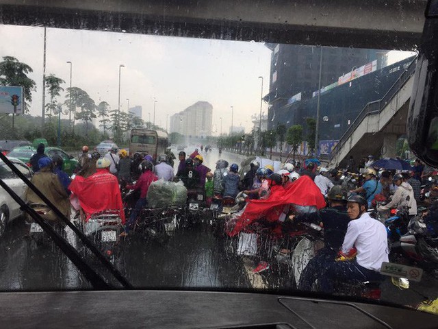 Hà Nội mưa dông lớn, hình ảnh trú mưa của người đi đường lại thành chủ đề gây tranh cãi - Ảnh 2.