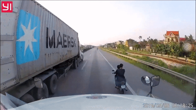 2 thanh niên không đội mũ, đánh võng song song với container đang chạy - Hành động đùa với tử thần