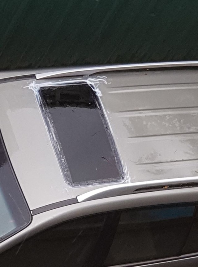 Chủ xe chống dột cho ô tô ngày mưa bằng cách dán băng dính kín cửa sổ trời - Ảnh 1.