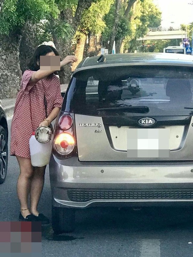 Tranh thủ đường đông, người phụ nữ cầm can xăng đổ cho ô tô ngay giữa phố Hà Nội - Ảnh 2.