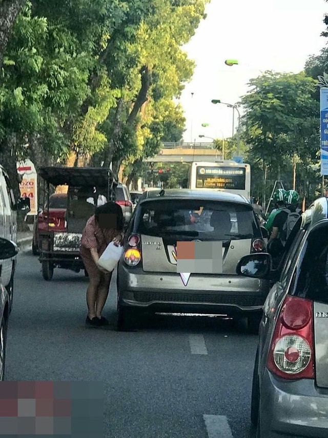  Tranh thủ đường đông, người phụ nữ cầm can xăng đổ cho ô tô ngay giữa phố Hà Nội - Ảnh 3.