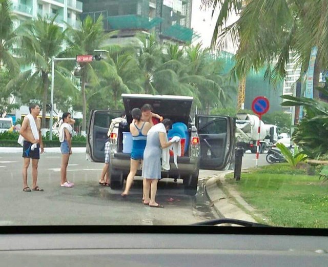 Góc khó hiểu: Đỗ xe bán tải Ford Ranger giữa đường, cả gia đình thản nhiên đứng tắm trên đường phố Đà Nẵng - Ảnh 1.