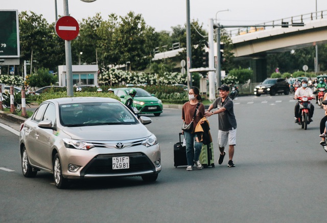 Khổ như hành khách ở Tân Sơn Nhất: Đội nắng mang vác hành lý ra đường đón xe công nghệ - Ảnh 12.