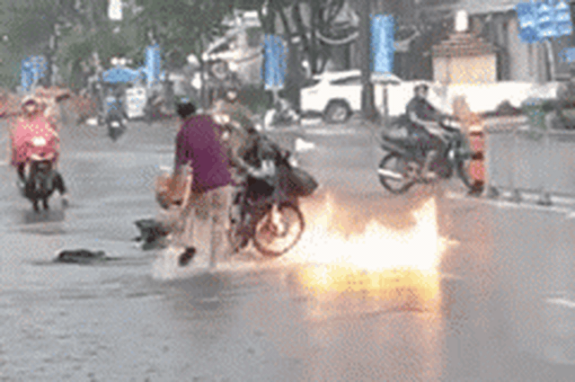 Xe máy bốc cháy giữa trời mưa lớn, hành động dập lửa của ba người đàn ông gây tranh cãi