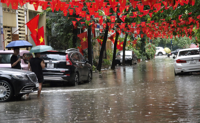 Toàn cảnh một buổi sáng "không tưởng" ở Hà Nội: Nước ngập đến thắt lưng, người dân vật lộn di chuyển giữa phố phường- Ảnh 1.