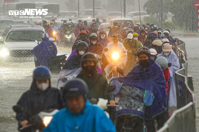 Loạt tuyến phố Hà Nội ngập nặng, người dân bì bõm dắt xe dưới mưa lớn- Ảnh 10.