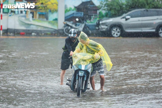 Loạt tuyến phố Hà Nội ngập nặng, người dân bì bõm dắt xe dưới mưa lớn- Ảnh 11.