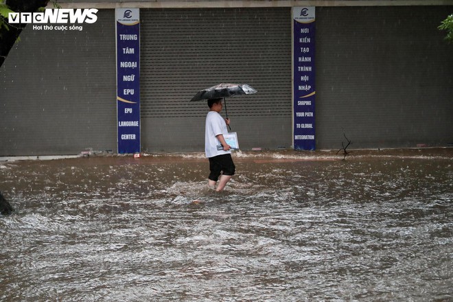 Loạt tuyến phố Hà Nội ngập nặng, người dân bì bõm dắt xe dưới mưa lớn- Ảnh 18.
